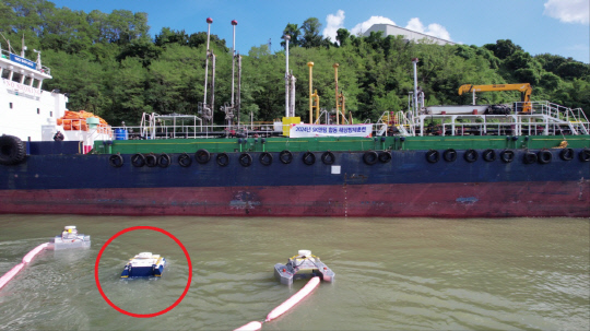 SK이노베이션이 투자한 스타트업 쉐코의 유회수기 방제로봇 '아크-M'(빨간색 원으로 표시)이 지난 20일 SK이노베이션 울산CLX 인근 SK부두에서 해상 방제훈련을 실시하고 있다. SK이노베이션 제공.